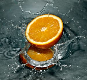 The wonderful picture of an orange nestling in a foundatin of fresh water.