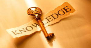 The picture of a key, overlaying a paper stating knowledge.