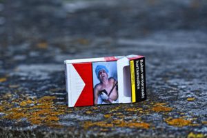 The picture of a cigarette pack with the illustration of someone dying from to habitual tabacoo use