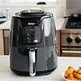 The picture of a Ninja air fryer sitting on a kitchen shelve.