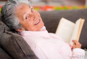 The amazing picture of an eldery woman reading and smiling.