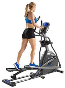 The picture of a very well toned woman on her Elliptical trainer.