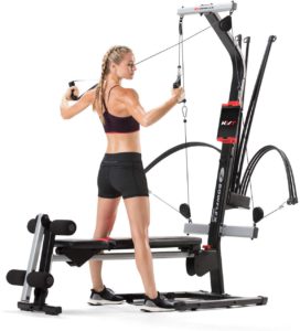 The picture of a woman engaging her Bowflex, PR 100, home gym.