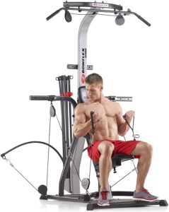 The picture of a man engaging his Bowflex PR 1000, home gym