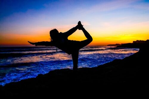 The amazing colorful picture of a person on one leg reaching out to the ocean during an amazing sunset, regarding best diet plans.